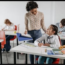 A teacher instructing students in a classroom.