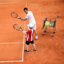 A tennis player carrying out a serve on court