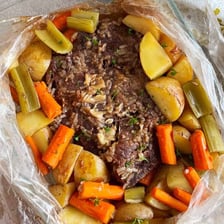 A roast cooking in a roasting pan
