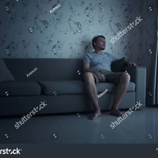 A bored person sitting with an unoccupied expression.