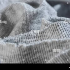 A close-up of fabric worn thin and threadbare.