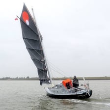 A sailing boat remaining afloat in open water.