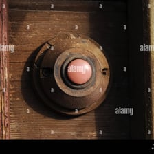 A close-up of a doorbell mounted beside a house door