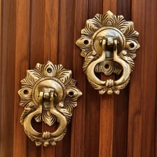 A traditional brass knocker mounted on a wooden door