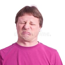 A person displaying a visibly sour or displeased facial expression.