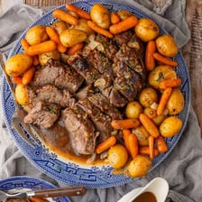 A roast cooking in a roasting pan.