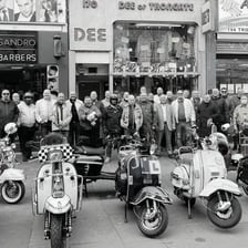 Several motor scooters parked on a city street.