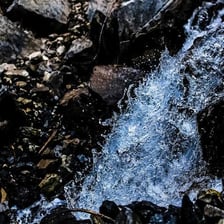 Water trickling gently over a bed of small rocks