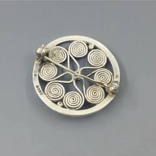 The metal clasp fastening on the back of a brooch.