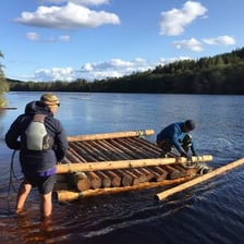 A simple wooden raft floating on a river
