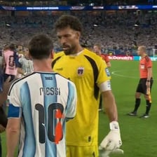 A footballer walking beside a partner at a sports stadium.