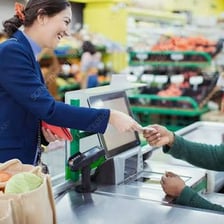 A person spending money by paying at a checkout