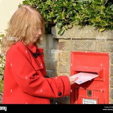 A person posting a letter into a mailbox