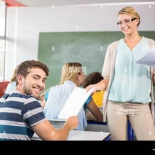 A person distributing papers to a group of students