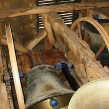 Large church bells hanging inside a bell tower