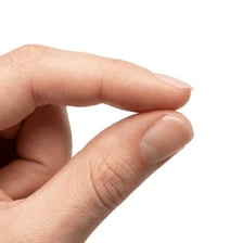 A tiny object shown on a fingertip to illustrate its small size.