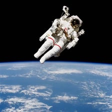 An astronaut floating outside a spacecraft in outer space.