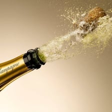 A Champagne cork popping out of a bottle