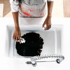 Fabric submerged in a bath of coloured dye.