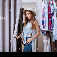 A person trying on a garment in a fitting room.
