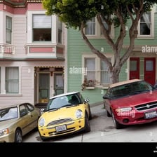 Several automobiles parked along an American street.