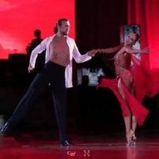 A dance couple performing the rumba in formal ballroom attire