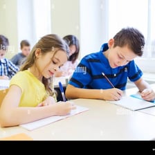 Students sitting desks and taking written examinations