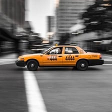 A taxi cab travelling along a city street