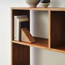 A wooden bookshelf with a visible horizontal shelf holding books.