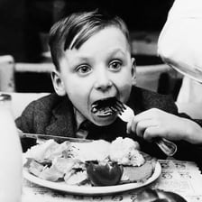 A person consuming food at a meal.