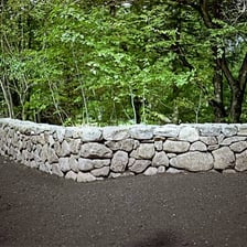 A mason laying stones while building a wall