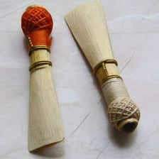A wooden orchestral oboe with its keys and reed