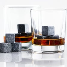 A glass of whiskey containing several ice cubes.