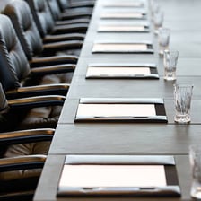People attending an annual general meeting in a boardroom