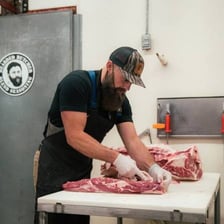 A butcher preparing meat in a shop