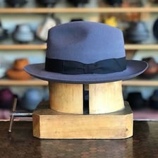 A classic trilby hat viewed from the side.