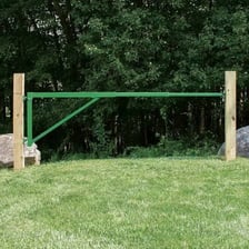 A garden gate attached to posts with visible hinges.