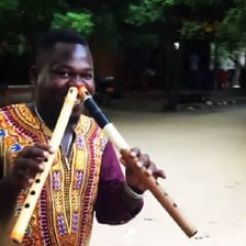 A person demonstrating a small nose flute