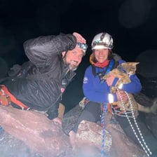 Rescuers helping a climber in a mountain setting.