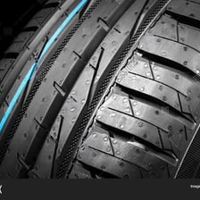 A close view of a rubber tyre fitted around a wheel