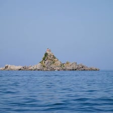 A small rocky islet surrounded by blue sea