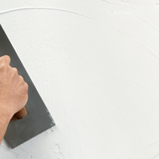 A mason applying render to a wall with a trowel