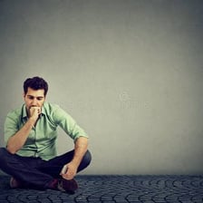 A person sitting alone with a visibly unhappy expression