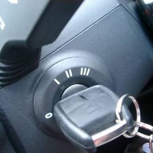 A set of car keys beside an ignition switch