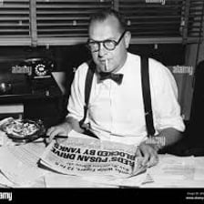 A newspaper editor reviewing pages at a desk