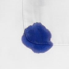 A dark ink stain visible on white shirt fabric