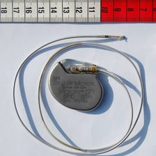 An implantable cardiac pacemaker shown as a small medical device
