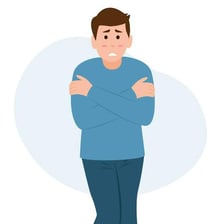 A person visibly shivering in the cold