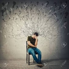 An anxious person sitting tensely on the edge of a chair