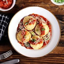 A plate of ravioli served with sauce.